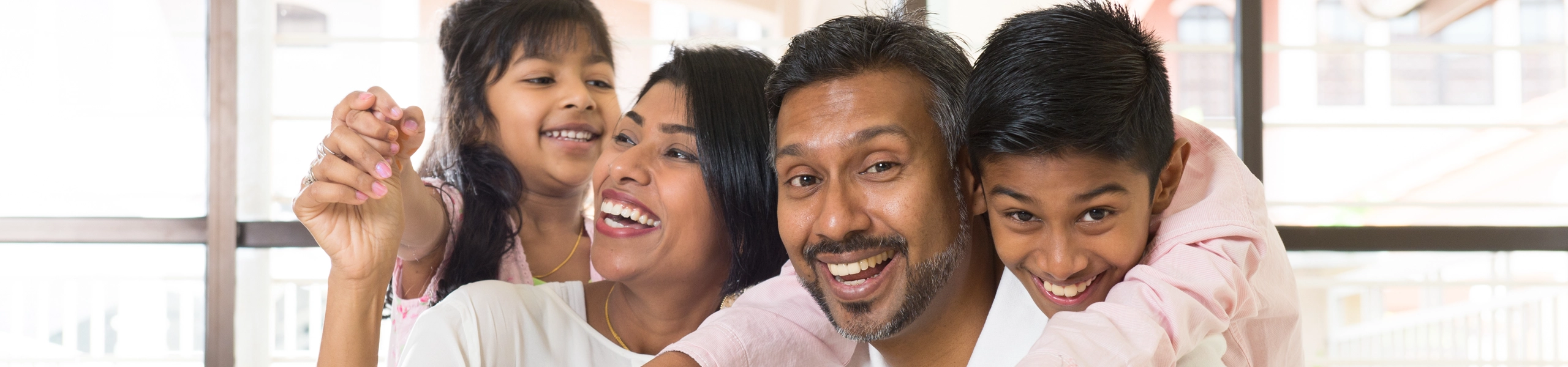 Happy family gathered around their computer to talk with their online therapist.