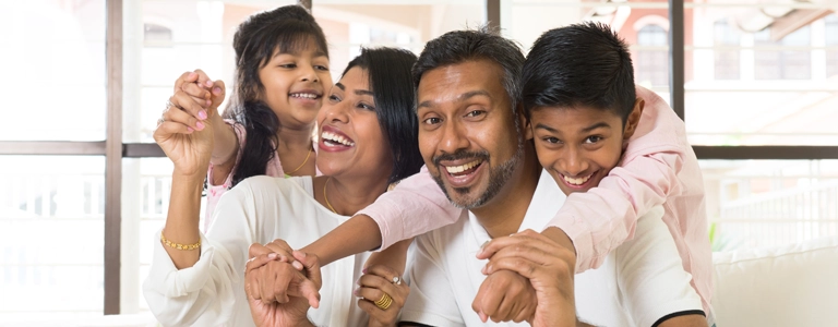 Happy family gathered around their computer to talk with their online therapist.